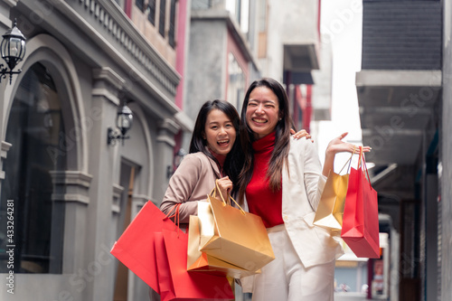 Two asian beautiful women with shopping bags in the city over mall background