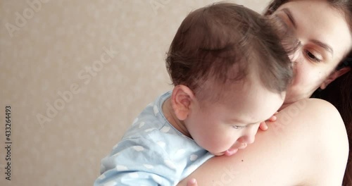 mom holds the baby in her arms and plays with him. Little cute Son plays with mom at home