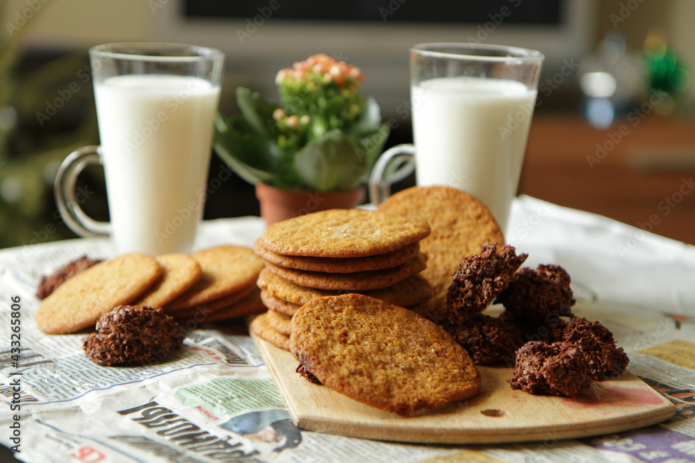 Almond cookies with nuts on a wood plank. cup of milk