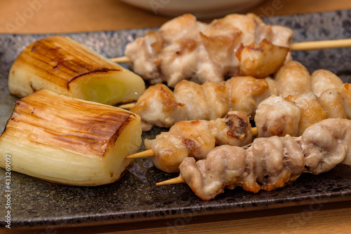 skewered chicken and green onions on a plate, Yakitori