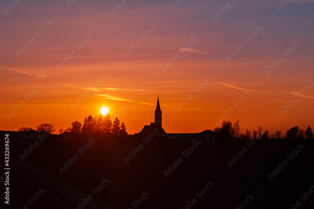 Beautiful sunset with a church silhouette near Kirchdorf, Bavaria, Germany