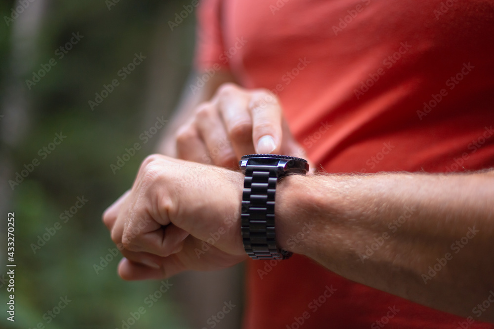 Close up of male hands, right-hand forefinger setting a data on a smartwatch