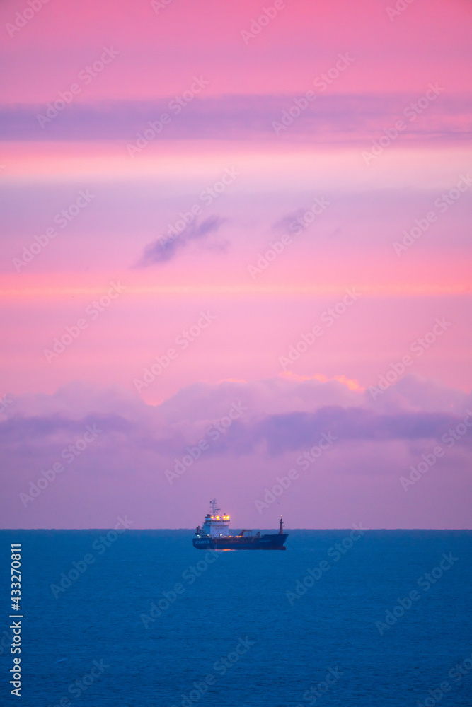 Fototapeta premium Ship in the Sea at Sunset