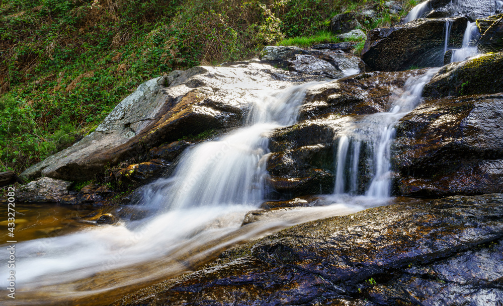 Panoramic of fresh water waterfall coming down from the mountain in long exposure photo. Navacerrada Madrid.