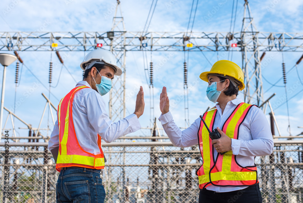 Asian male and female electrician a wearing face mask hello shake hand new normal social distancing, No touching Asian male and female electrician a wearing face mask hello shake hand new normal social distancing, No touching