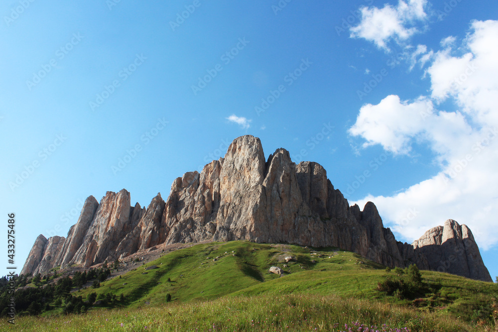 The teeth of the majestic rocks rise above the green meadows. Mountain hike through the Caucasian reserve. Big Thach