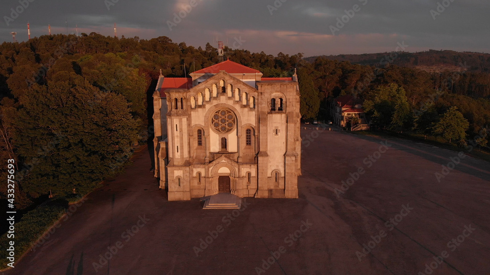 Fototapeta premium DRONE AERIAL VIEW: Facade of the church of Nossa Senhora da Assuncao (Our Lady of Assumption) in the hill of Monte Cordoba at sunset in Santo Tirso, Portugal.