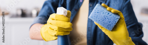 Φωτογραφία Cropped view of woman in rubber gloves holding detergent and blurred sponge, ban