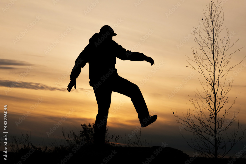 silhouette of a walking man on the background of sunset silhouette of a walking man on the background of sunset