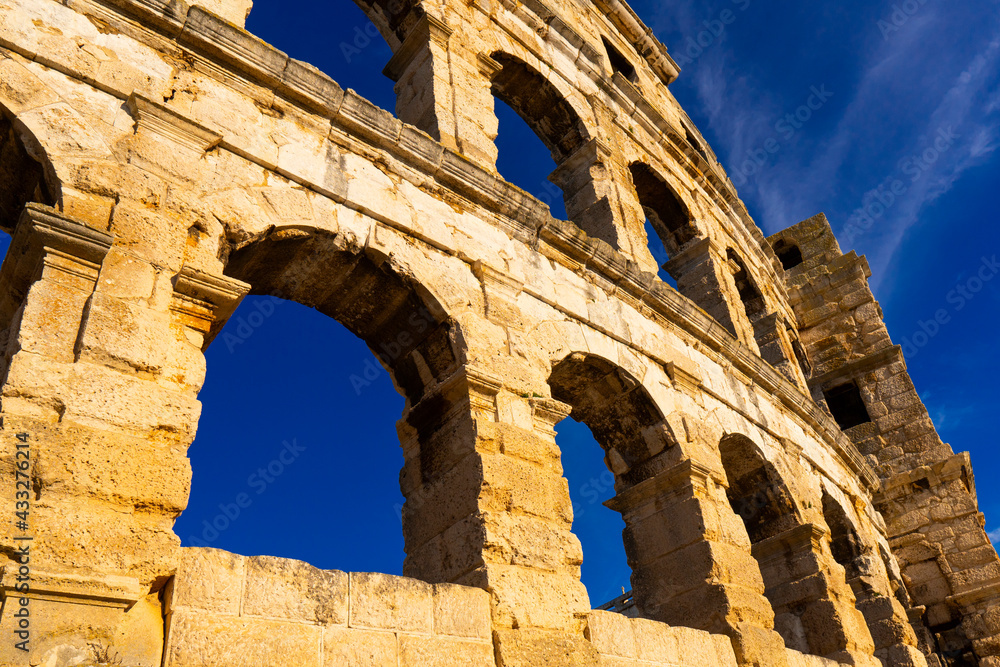 Sunny weather. The walls of the ancient Roman amphitheater against the blue sky Sunny weather. The walls of the ancient Roman amphitheater against the blue sky