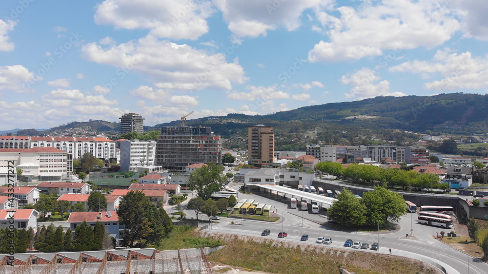 Santo Tirso, Portugal - May 1, 2021: DRONE AERIAL VIEW: Santo Tirso Bus Station Terminal. Crowd of urban passenger transport buses parked together.