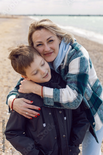 Obraz na płótnie mom and her teenage son are standing next to the sea w salonie