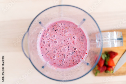 Fresh smoothie in blender on table