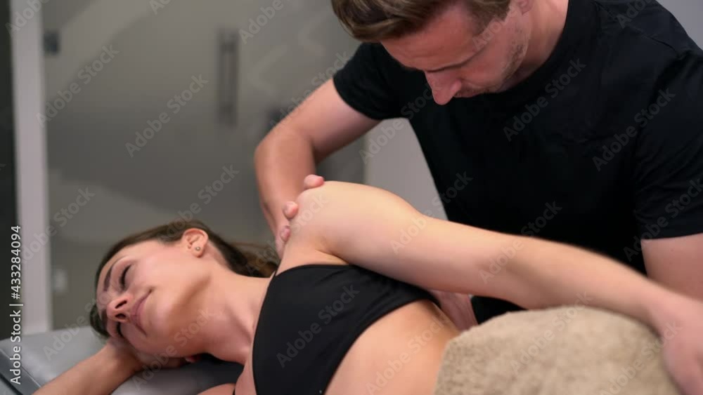 Physiotherapist checking up arm of woman in clinic Physiotherapist checking up arm of woman in clinic