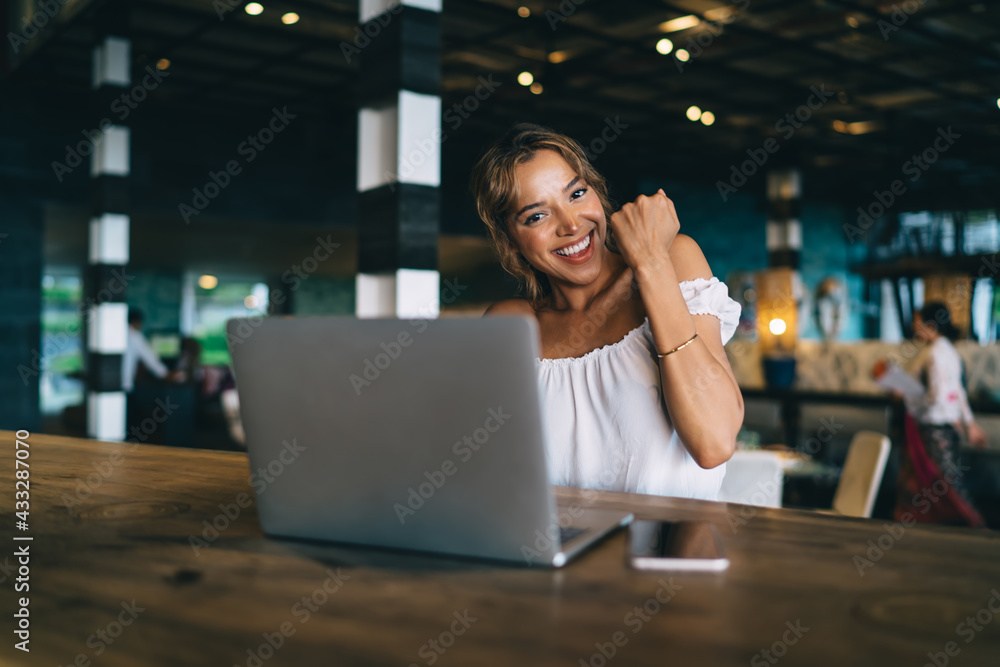 Excited woman with laptop in modern cafe Excited woman with laptop in modern cafe