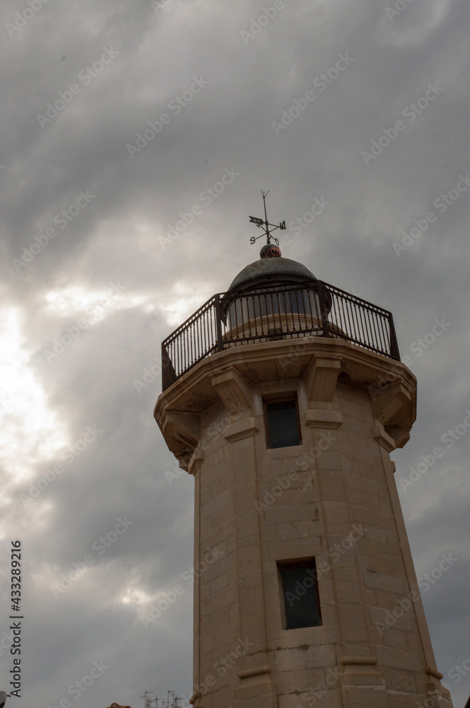 part of the grao lighthouse with cloudy sky in the background