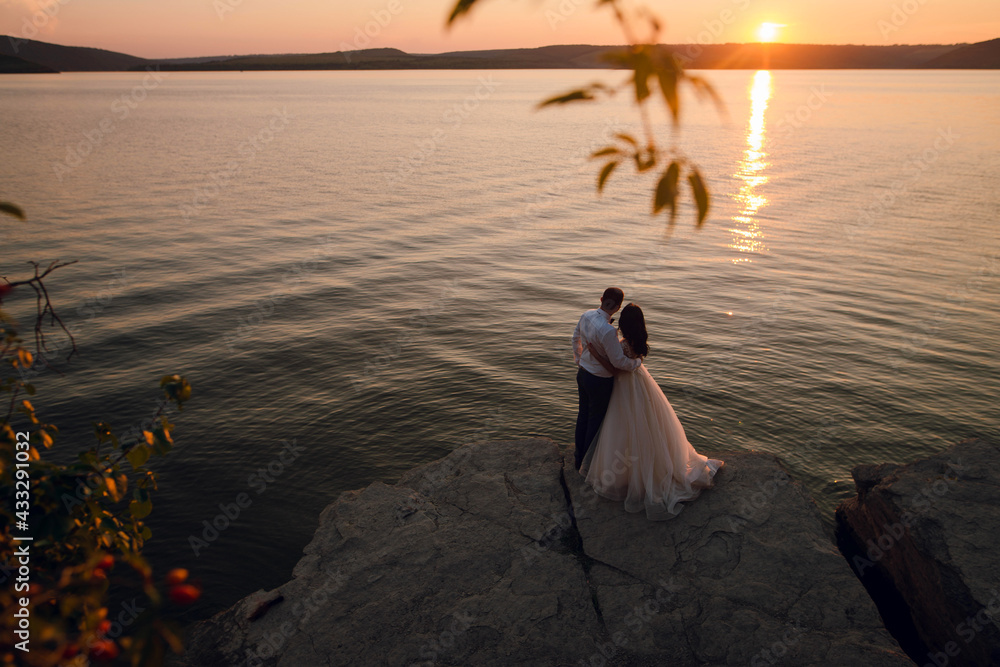 Fototapeta premium Sensual wedding couple groom and bride near the beautiful lake