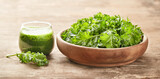 Healthy green kale smoothie with kale salad on wooden board