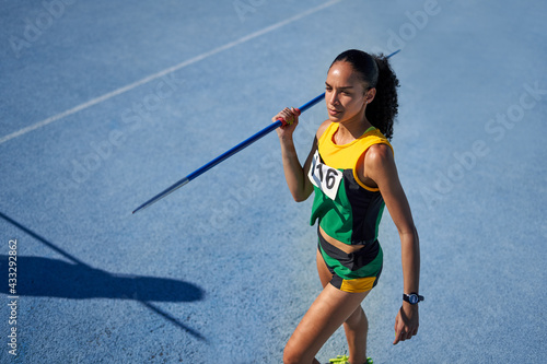 Female track and field athlete preparing to throw javelin on track photo