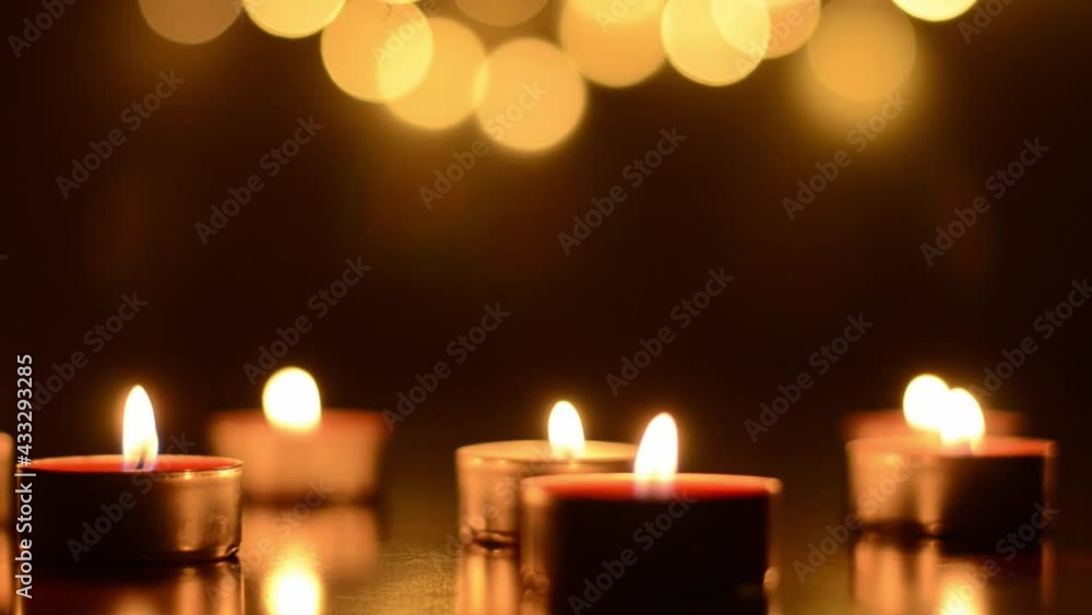 Top view of burning candles with festive bokeh on a black background. Holiday concept. The concept of prayer and hope. Top view of burning candles with festive bokeh on a black background. Holiday concept. The concept of prayer and hope.