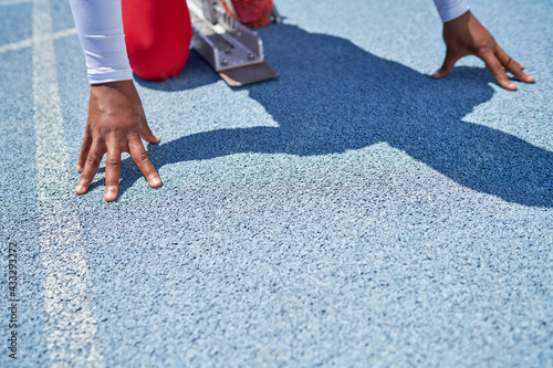 Close up hands of female track and field athlete at starting block