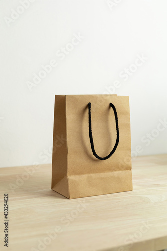 brown paper shopping bag on wooden table
