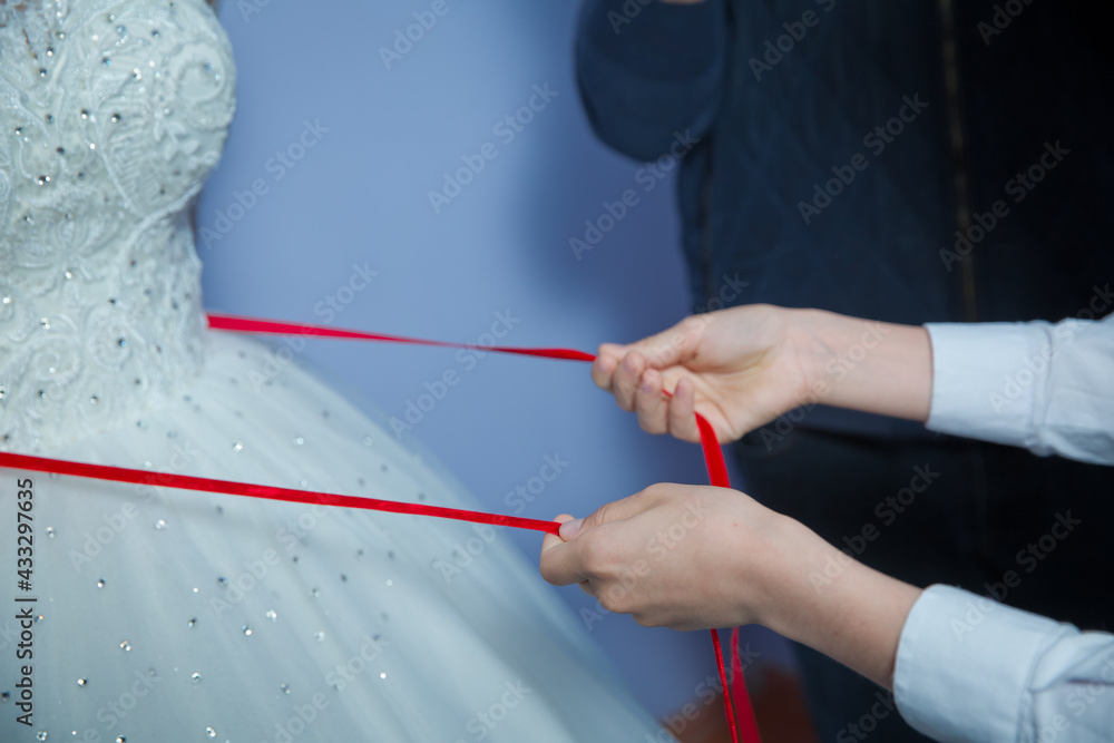 Wedding . Bridesmaids lace bride . Close the ribbon on the belly the bride . Close the ribbon on the belly of the bride . Lose the ribbon on the belly of the bride .