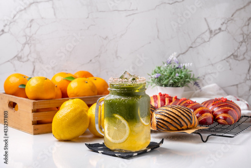 Cold lemon honey matcha, decorated with lemon on a white table, white tone picture style gives a refreshing feeling in the morning.