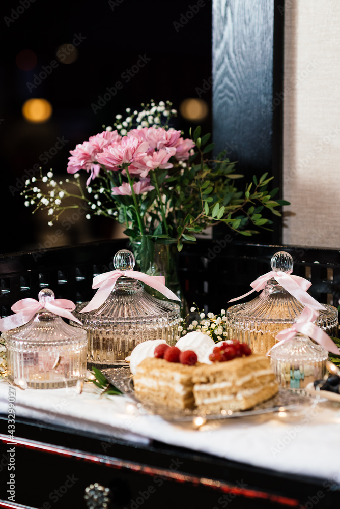 cakes on a plate and pink flowers in a vase
