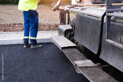 The road workers' working group updates part of the road with fresh hot asphalt and smoothes it for repair