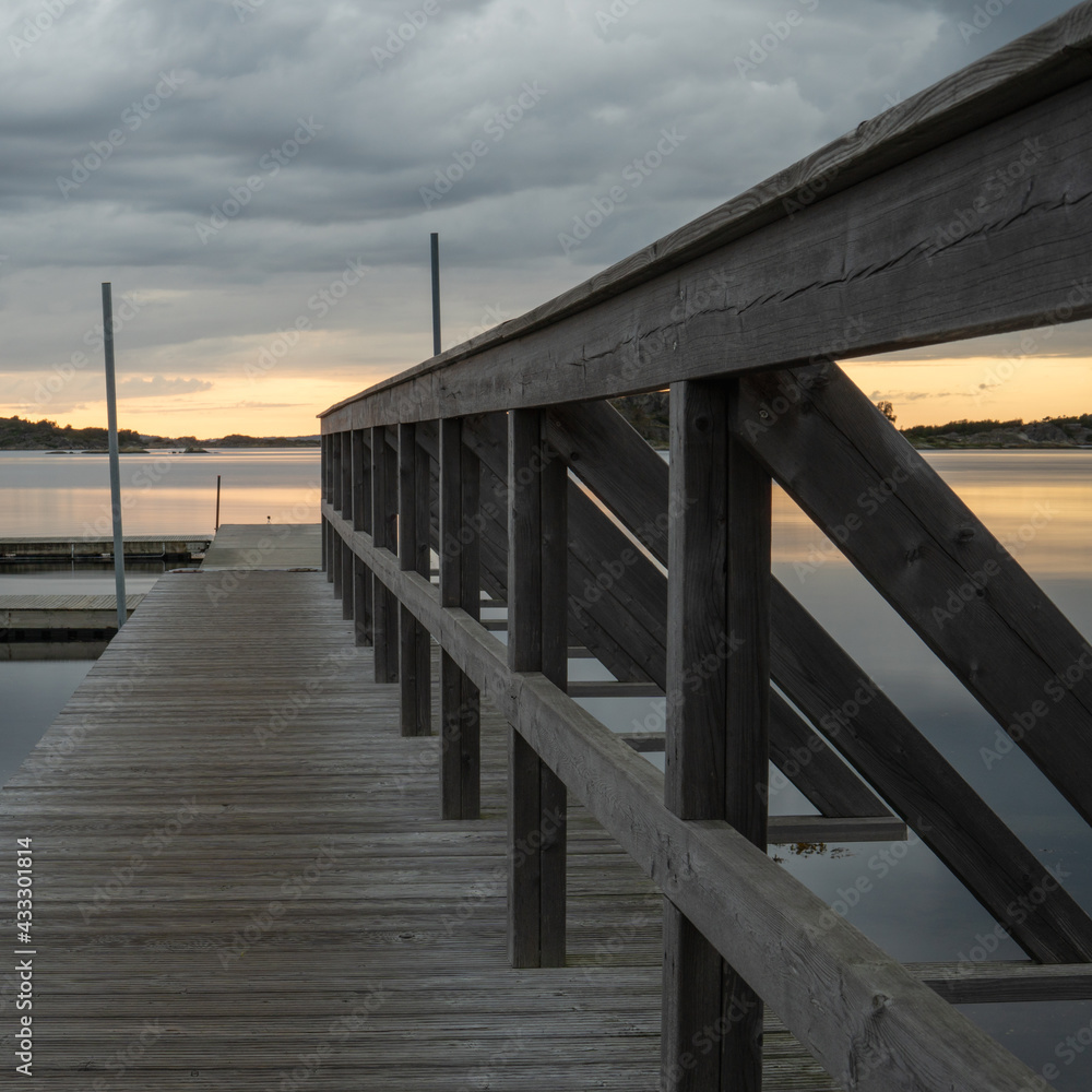 Wooden bridge to the water. Calm summer night on the Swedish west coast.
