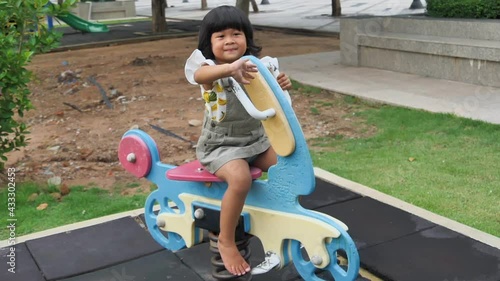 Little kid are playing with rocking horse at the playground, kids having fun and say hi motion, activities kids, smiling, enjoy and leaning outdoor of kids concept, slow motion concept.