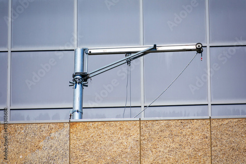Swiveling davit arm is attached to the building rooftop structure photo