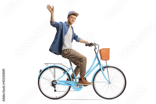 Full length profile shot of a guy riding a city bicycle and waving at camera