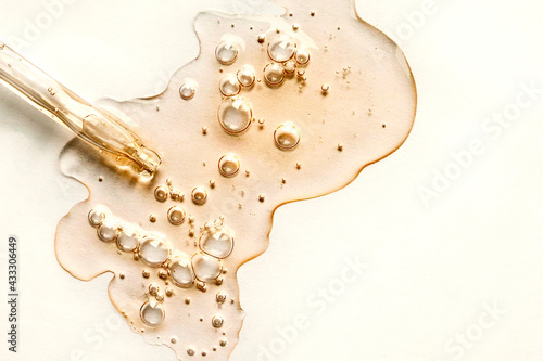 Yellow texture of a drop of whey or olive oil on a white background. Transparent sample of cosmetic gel with bubbles. Golden acid cream. Vitamin c. A drop of honey. Hyaluronic acid. photo