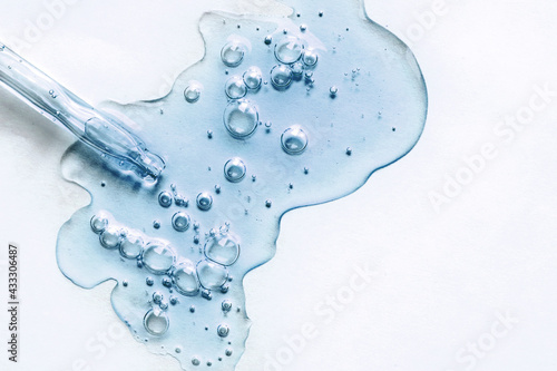 Blue texture of a drop of serum on a white background. Transparent sample of cosmetic gel with bubbles. Crystal acid cream. Hyaluronic acid. photo