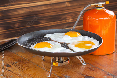 fried eggs in a skillet on a portable camping stove.