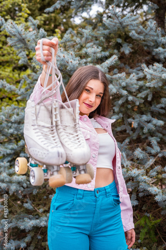 Chica enseñando patines desenfocados en la naturaleza