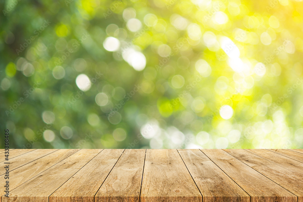 Wood floor with blurred trees of nature park background and summer season, product display montage Wood floor with blurred trees of nature park background and summer season, product display montage