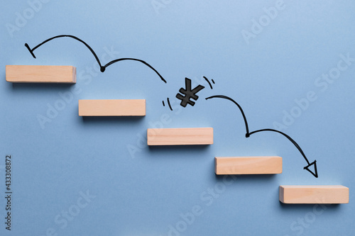 Fotografie Concept of falling yen currency rate on stairs with down arrow