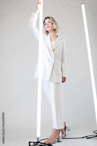 singer posing in the studio. Around the girl neon lamps