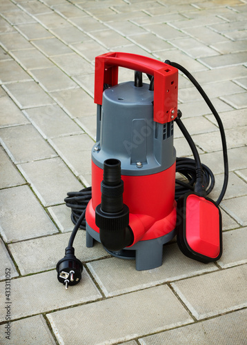 Household submersible pump with plastic housing  on stone floor