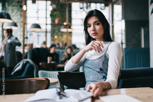 Serious woman with phone and notebook