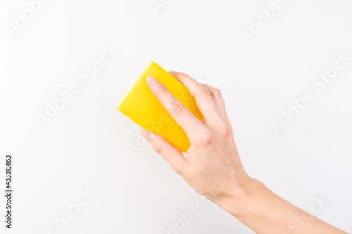 Sponge for washing dishes in female hand. Woman's hand gesture or sign isolated on white. A hand holds a sponge for washing and cleaning dishes