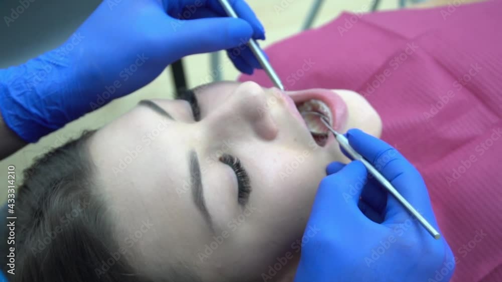 Close up shot of dentist preparing to do oral checkup of the patient Close up shot of dentist preparing to do oral checkup of the patient