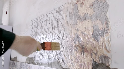 Men's hand with a brush puts on the wall primer