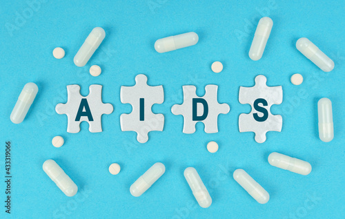 On a blue background, there are pills and puzzles with the inscription - AIDS