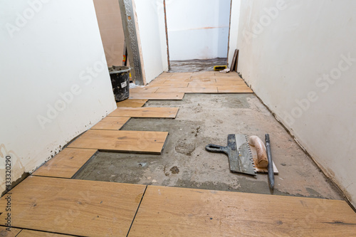 Process of installation of parquet tiles or laminate in apartment is under construction, remodeling, renovation, overhaul, extension, restoration and reconstruction.