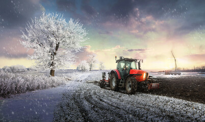 Tractor plowing a field in winter