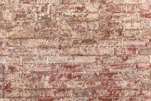 old red brick wall painted with white with color peeling